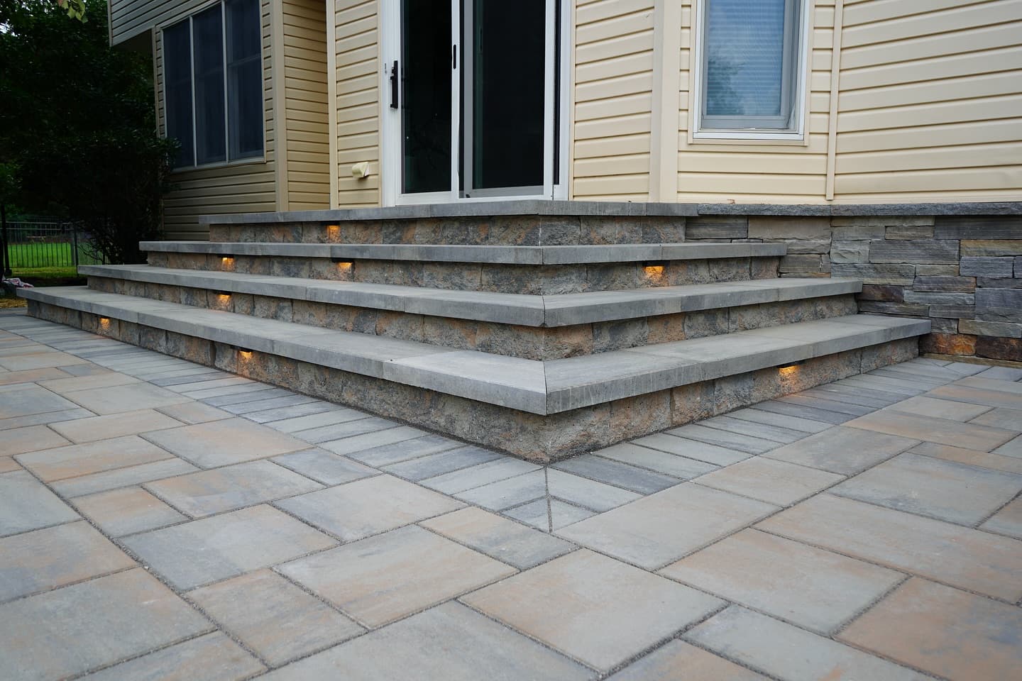 Paver steps with lighting and stone veneer patio