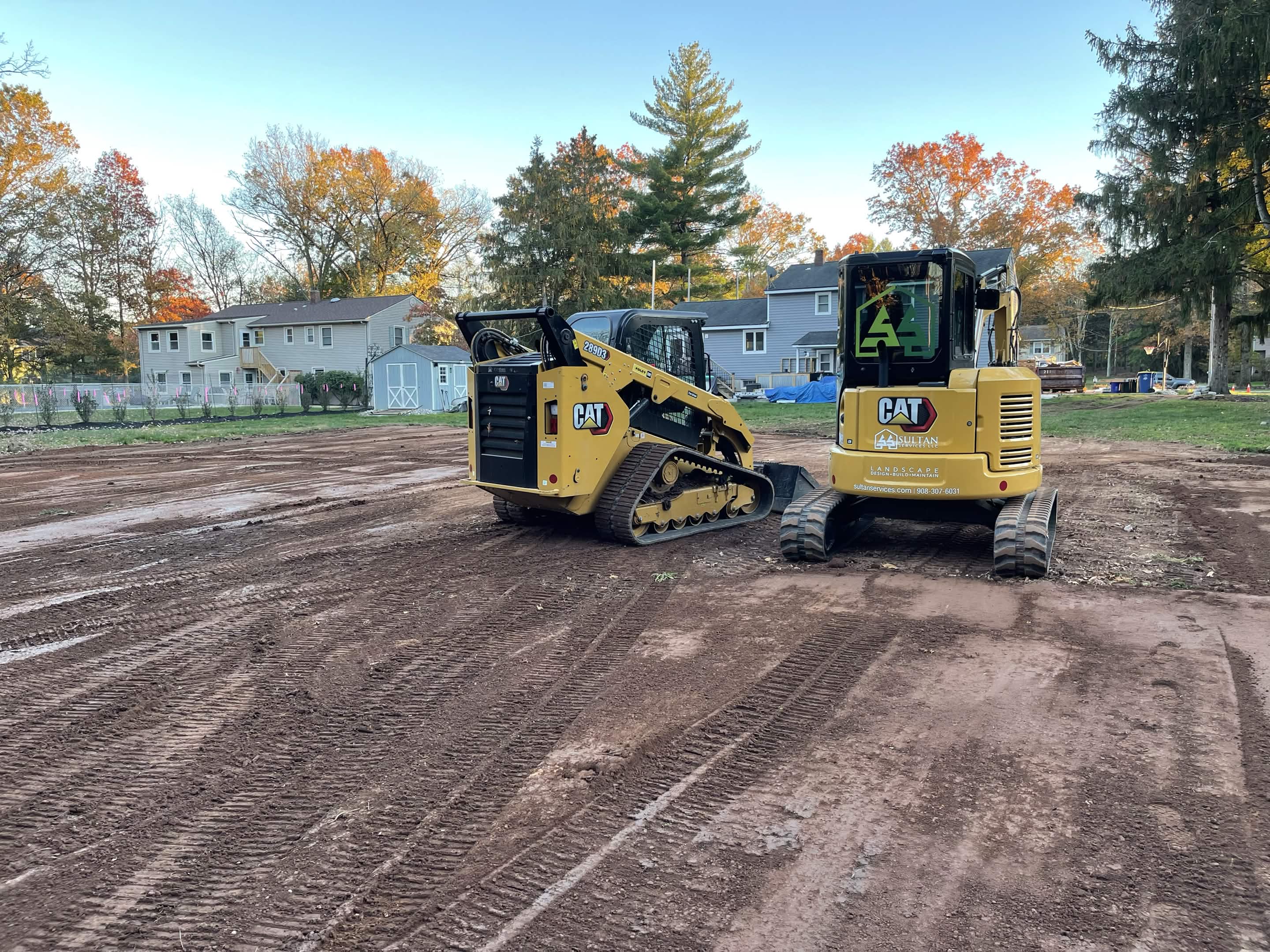 CAT skid steer and mini excavator grading residential lot