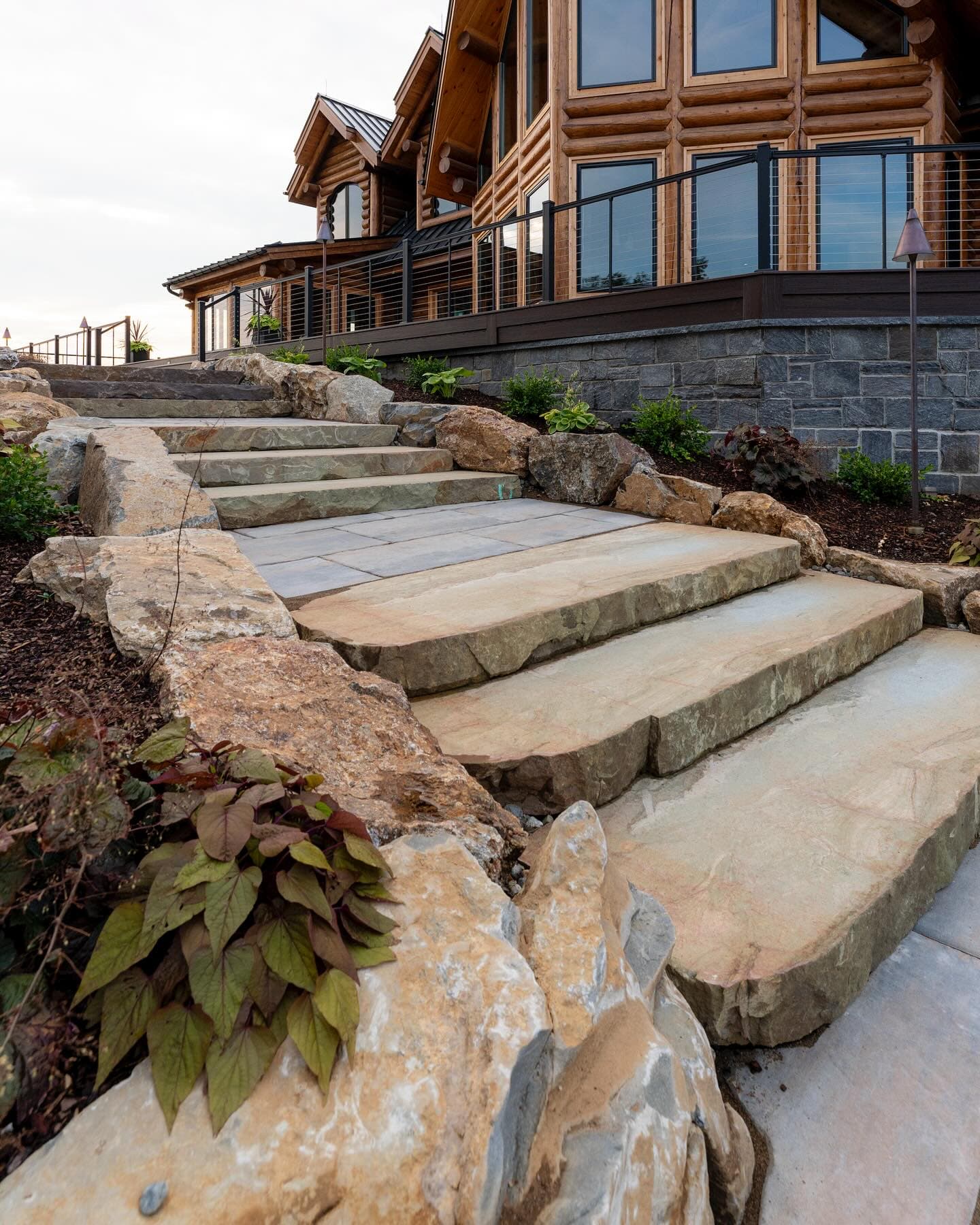 Natural stone steps with boulder borders leading to home entry