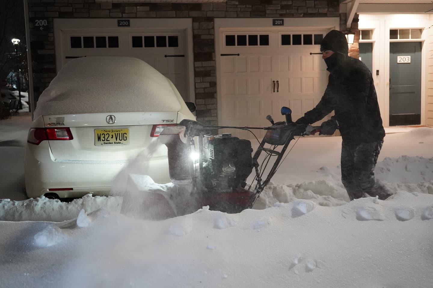Crew member clearing townhome driveway with snowblower