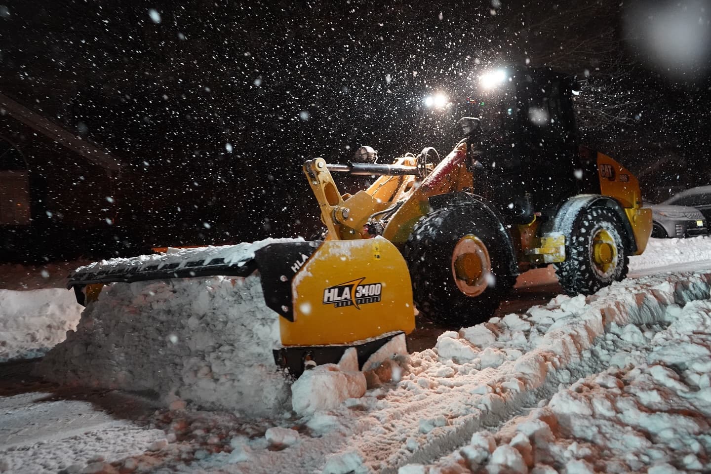HLA loader with pusher box clearing snow at night