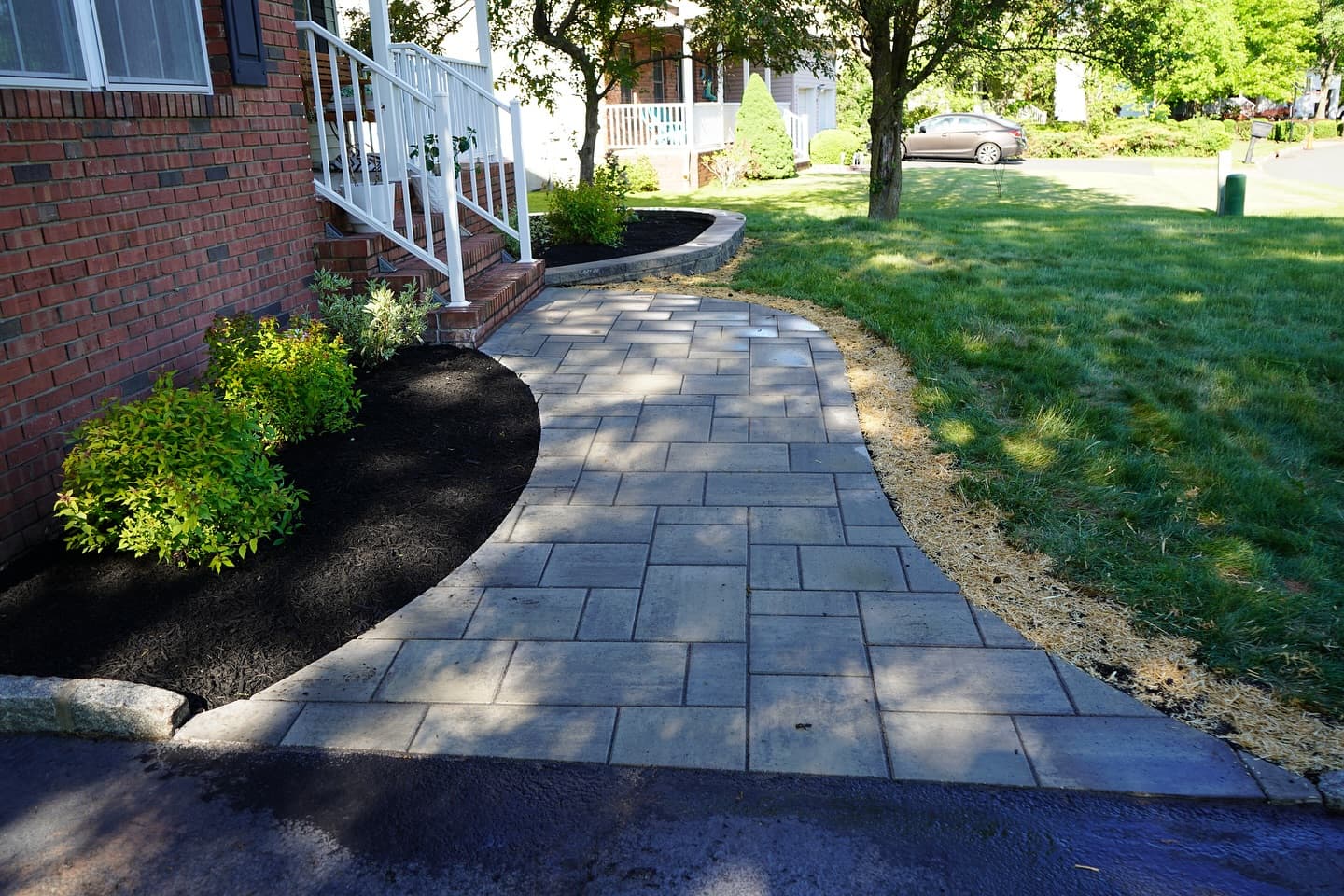 Curved paver walkway with garden wall and planting