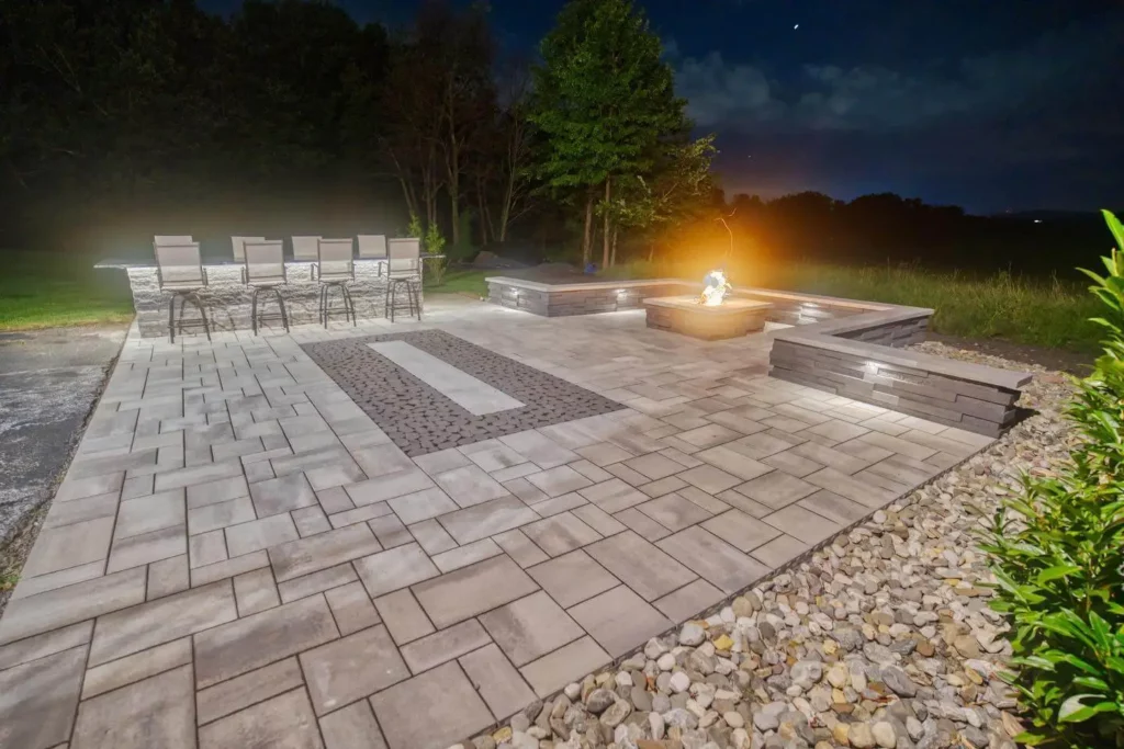 Hardscape Design and Installation: Patio with bar and fire going at night